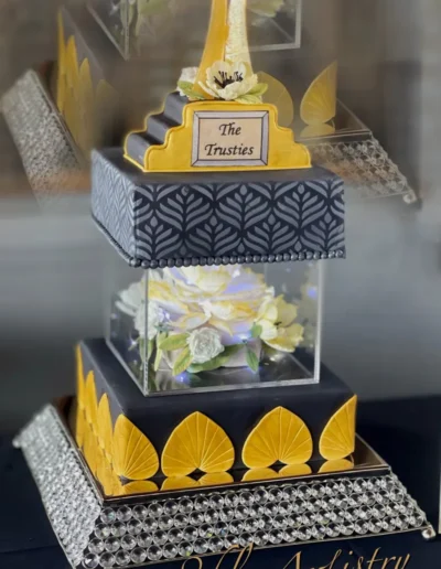Elegant geometric wedding cake with floral accents and modern tiered detailing