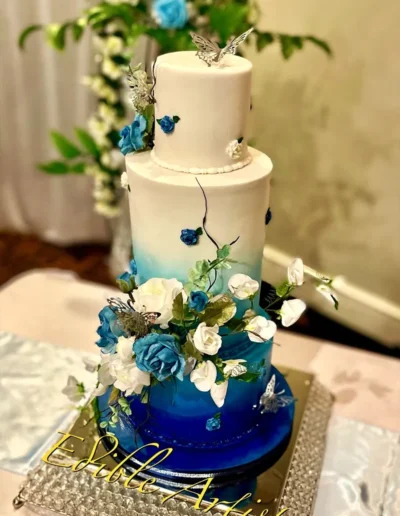Elegant blue and white wedding cake with floral and butterfly detailing