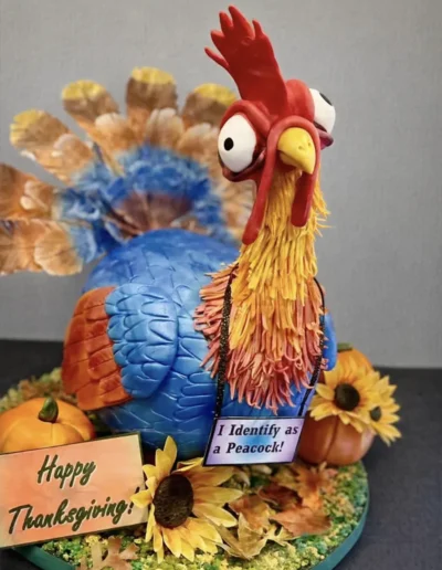 Custom turkey cake with colorful feather detailing and Thanksgiving decorations.