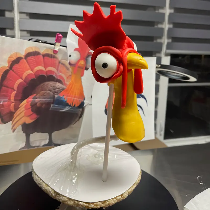Initial rooster cake structure and character modeling in progress during the cake decorating process